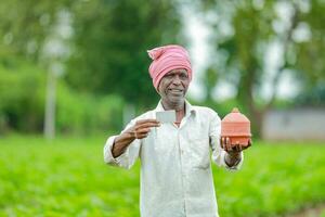 Indian farmer Holding gullak in hand, saving concept, happy poor farmer photo