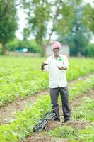 Indian happy farmer holding empty Bottle in hands, happy farmer showing white Bottle photo