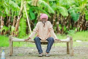 contento indio agricultor. plátano planta, antiguo pobre granjero , trabajador foto