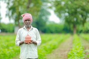 Indian farmer Holding gullak in hand, saving concept, happy poor farmer photo