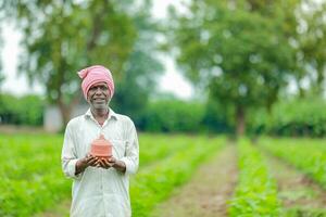 Indian farmer Holding gullak in hand, saving concept, happy poor farmer photo