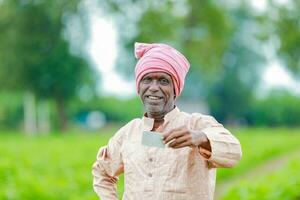 indio granjero participación gullak en mano, ahorro concepto, contento pobre granjero foto