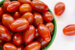 Fresh red cherry tomatoes on light background photo