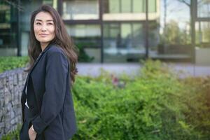 Asian confident business woman in suit smiling, looking up. Job, work aspirational banner copy space photo