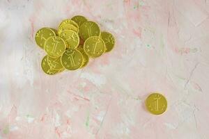 Lucky gold chocolate coins on pink background photo