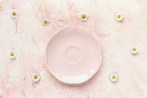 Pink saucer and fresh summer daisy flowers photo