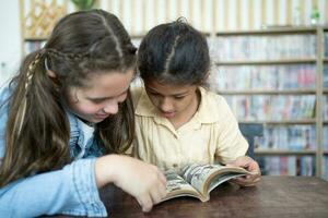 dos niños a el mesa leyendo el libro espalda a escuela. comenzando de colegio lecciones foto