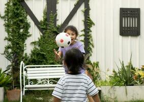 Funny Little Boy and girl Playing  Ball in garden photo