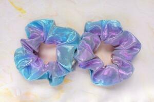 Two trendy holographic scrunchies on pink background photo