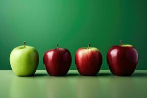 Tres manzanas de diferente colores forrado arriba en un verde mesa foto