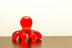 Red hand plastic massager in the shape of an octopus photo