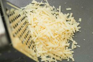 Grated hard parmesan cheese on the table photo