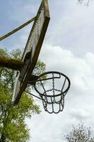 An iron basketball hoop in the open air against a blue sky background. Basketball hoop with iron net. photo