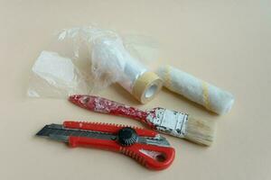 un conjunto de del pintor herramientas. un pintar cepillar, un espátula y un cuchillo para el constructor. enmascaramiento cinta. artesanía foto