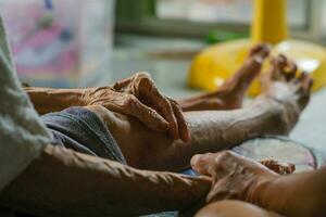 The hand of an elderly person who shakes hands with a young man with warm concern It was a family visit. traditions of the Thai people photo