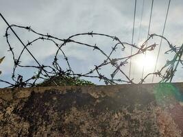 an iron wire that is above the wall to prevent thieves from entering the house photo