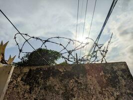 an iron wire that is above the wall to prevent thieves from entering the house photo