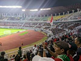 Surabaya, indonesia - 22 june 2023 - A view and atmosphere with many indonesia supporter at gelora bung tomo. Indonesia vs palestina friendly match. photo