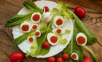 background of red caviar on dsrk wooden surface. tartlets with red caviar photo