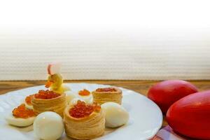 background of red caviar on dsrk wooden surface. tartlets with red caviar photo