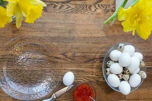 Top view of a bowl of boiled eggs and red caviar on wooden table, heathy breakfast meal photo