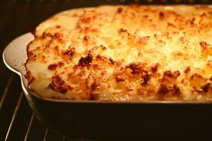 Cooking comfort food and traditional English cuisine, fish pie baking in the oven in countryside kitchen, homemade recipe photo