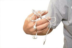 a man with tangled headphones in a twisted mess isolate white background photo