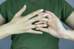 A woman is holding a wedding ring. Concept of love, family. Upset girl holding wedding ring, depressed due to divorce, divorce. photo