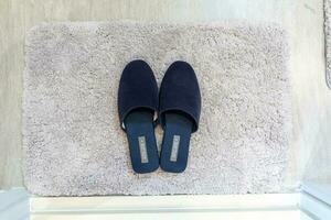 Top view blue fluffy slippers separate on the white fur rug photo