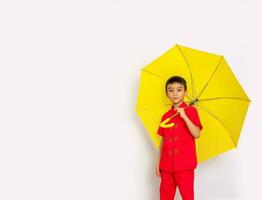 boy fashion a Chinese-style shirt holding a yellow umbrella poses for a photo shoot.