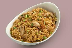 A stylish bowl of chicken noodles with onion photo