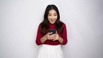 Happy young Asian woman feel overjoyed celebrating bid win success victory looking at smartphone, screaming yes winning online game app on cell phone at home video