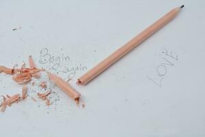 Broken pencil. Writing with a pencil the word love. White background. photo