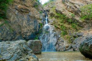 The waterfall flows between the rocks photo