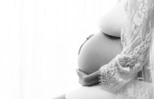 Portrait of a pregnant woman touching her big belly close up, mother, pregnancy, people and expectation. Woman holding big pregnant stomach photo