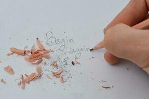 broken pencil writing with a pencil Written word begin again white background photo