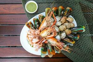 Seafood prawns prawns mussels clams on plate and dark background-cooked food photo