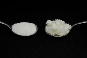 1 spoon of rice and 1 spoon of sugar Same amount of calories each day, two spoons, isolate black background photo