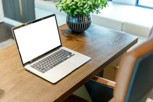 Side view of contemporary workplace with laptop computer, notebook, on wooden table photo