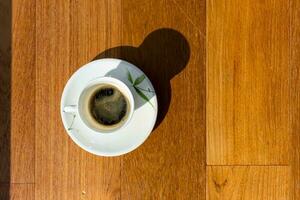 Cup of fresh coffee on wooden background, top view photo