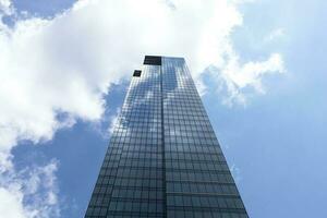 centro, vaso rascacielos o torre y azul brillante cielo en antecedentes. negocio desarrollo o financiero centrar concepto. Copiar espacio en bien. horizontal avión. moderno edificio. alto calidad foto