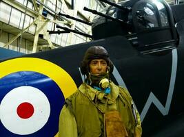 London  England, UK  June 29, 2014 Royal Air Force RAF Museum. Real historic aircrafts from all over the world. In foreground a pilot close to a British Defiant. photo