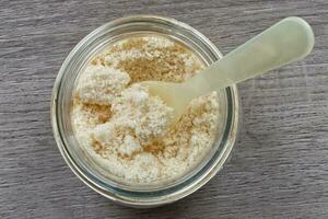 Grated Italian Parmigiano Reggiano cheese on wooden table photo