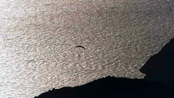 parapendio volante con parapendio nel cielo al di sopra di il foresta, montagna superiore e mare video