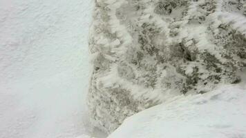 neve strati accumulando su roccia nel il difficile tempestoso freddo tempo metereologico nel inverno video