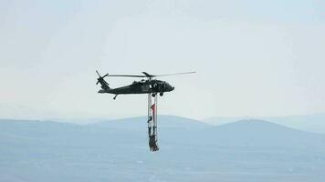 mensen hangende van helikopter het uitvoeren van stunt vliegend video