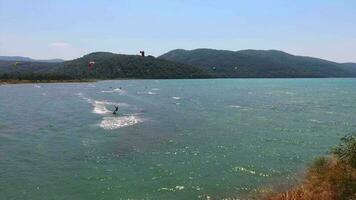 kitesurf, kite surf les kiteurs et kiteboarders sont tiré à travers mer l'eau par une vent Puissance cerf-volant video
