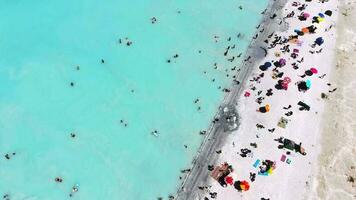 personas nadar en vacaciones en el blanco arenoso playa de el claro tropical turquesa ligero azul mar video