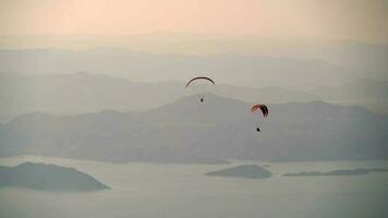 paragliders vliegend met paragliden in lucht over- de Woud, berg top en zee video