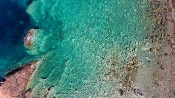claro y superficial mar agua de el ensenada rodeado por Roca y rocoso línea costera video